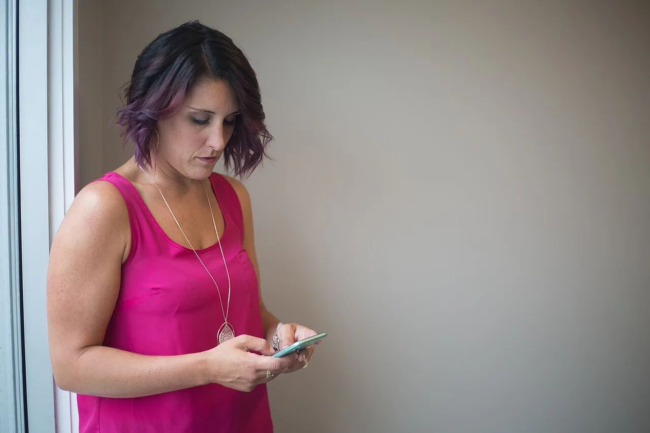 A woman using a smartphone to compare live cam sites
